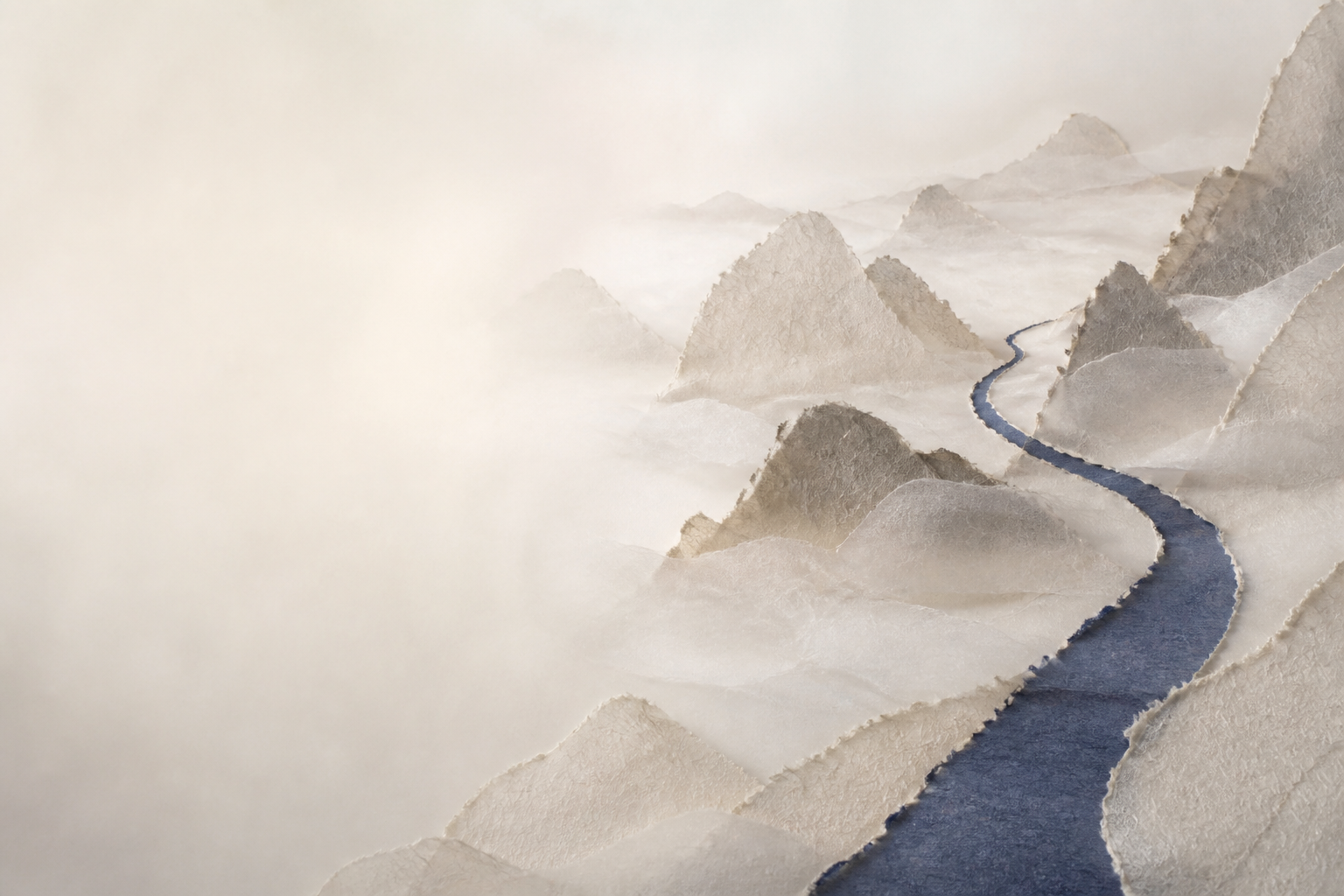 An indigo path emerging through misty paper mountains